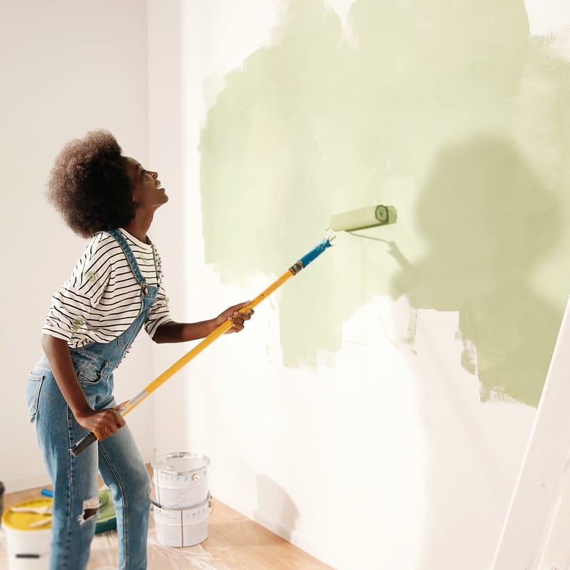 image of woman rolling fresh paint on wall